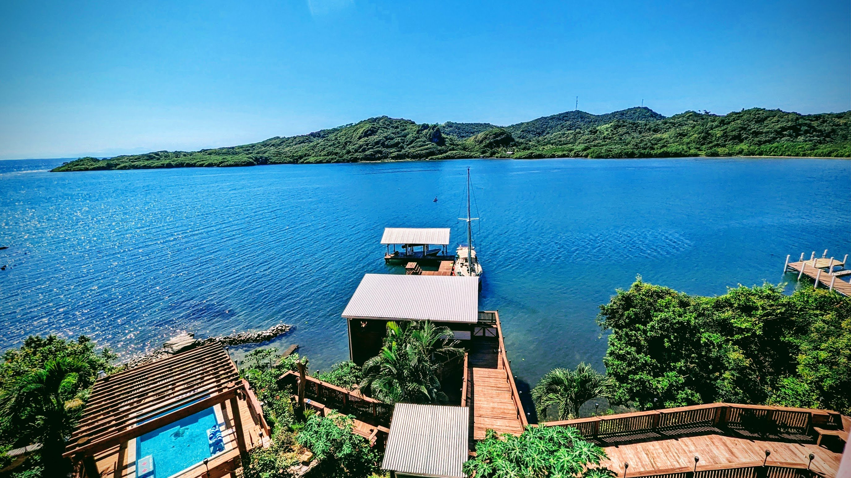 View from The Crown balcony — pool, dock, La Rosa, and Carib Bight, El Palacio Rosa Roatan