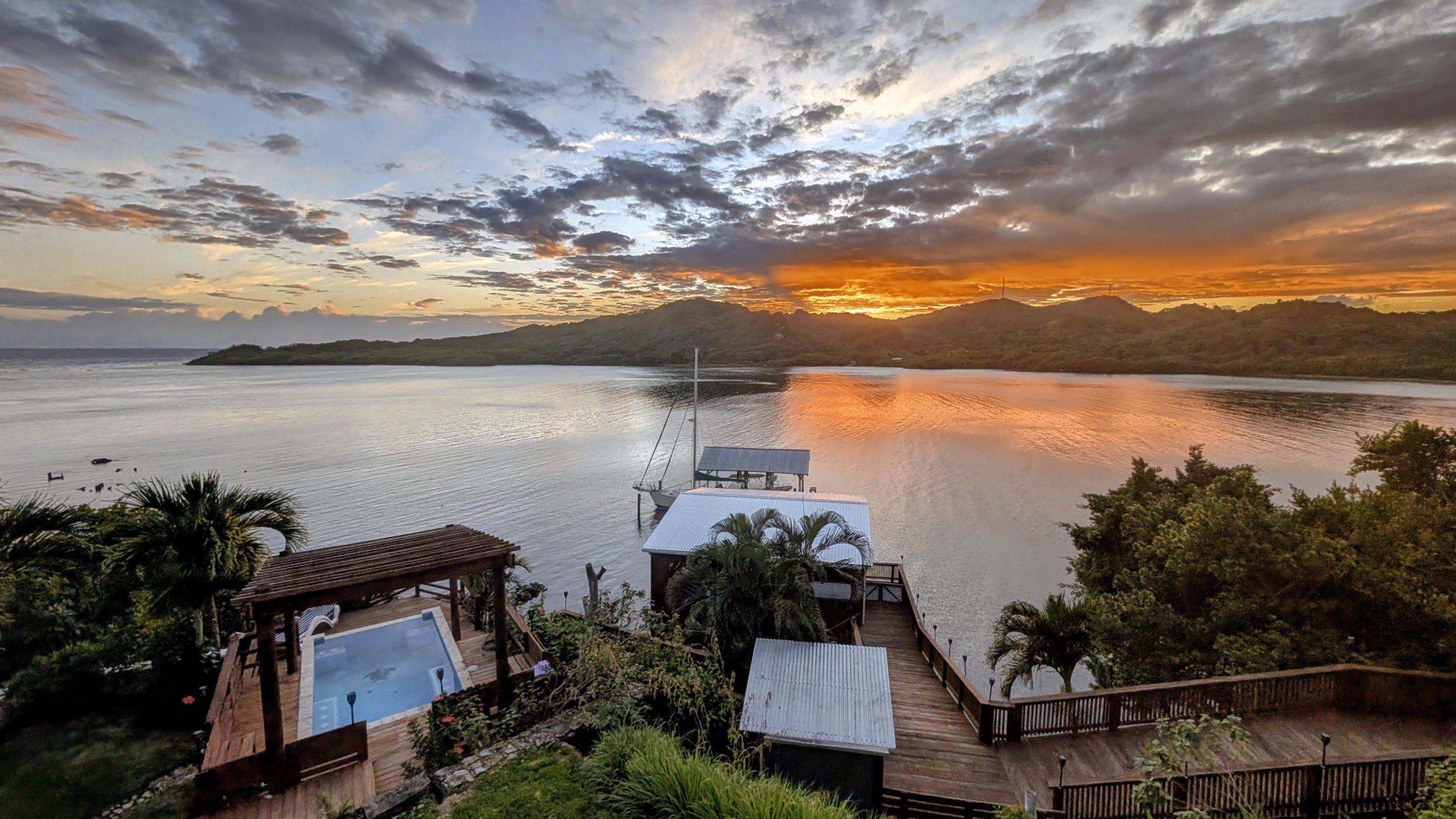 View from The Palace — pool, dock, and Carib Bight at sunset