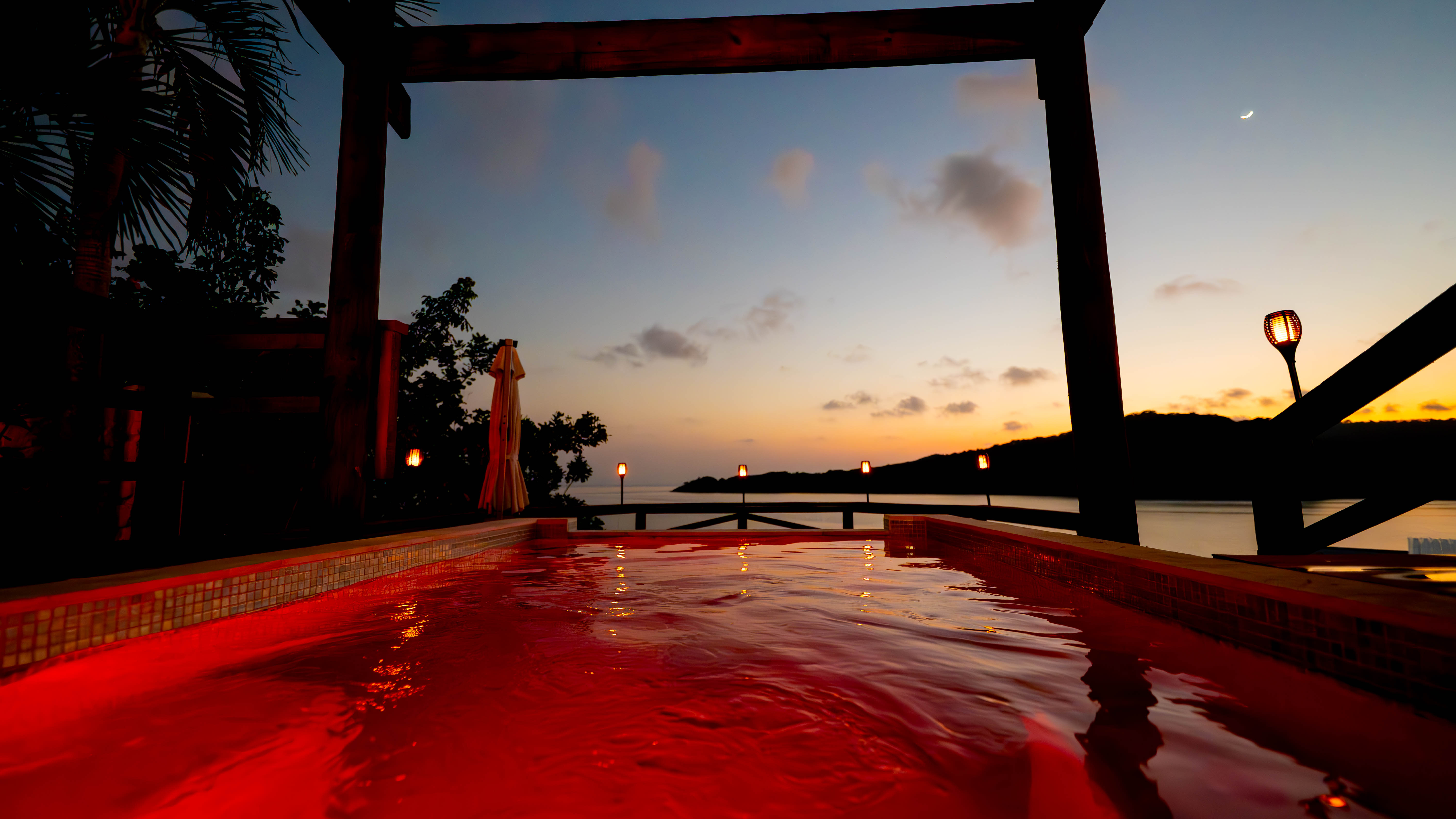 RGBW color-lit infinity pool at dusk
